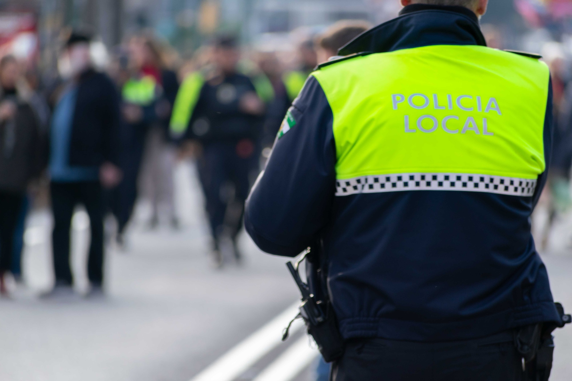 Closeup shot of a police officer with "local police" written on the uniform in Spanish